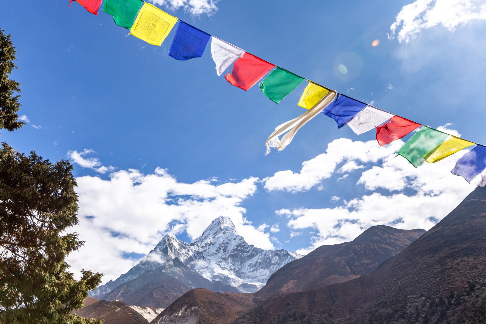 Horizontal Tibetan lungta prayer flags strung across a sky with Ama Dablam peak