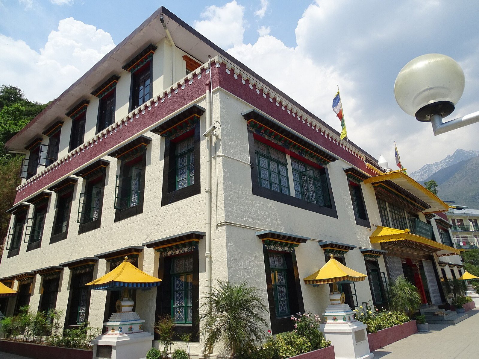 A three-storey Tibetan-style library building with painted window frames and yellow parasols